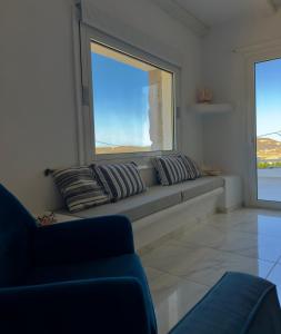 a window seat in a living room with a couch at Villa Greystone & Sky Mykonos in Tourlos +55 photos