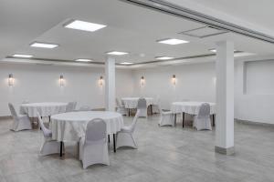 a room with white tables and chairs and a white wall at Best Western Gregory Hotel in Brooklyn