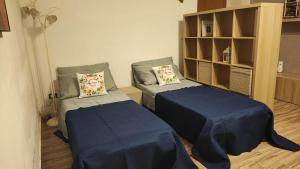 a room with two beds and a book shelf at Sicilia Bedda C&G in Acireale +11 photos