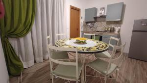 a kitchen with a table and chairs with a bowl on it at Sicilia Bedda C&G in Acireale