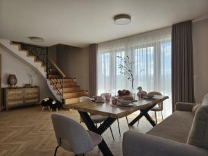 a living room with a table and a staircase at Apartamenty Klikuszówka in Nowy Targ