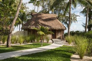 a hut with a thatched roof and a path at Le Tikehau by Pearl Resorts in Tikehau