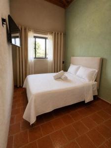 a bedroom with a large white bed with a window at Hotel Mary o in Valle de Bravo