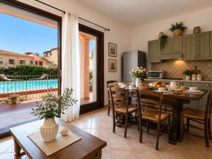 a kitchen and dining room with a table and a pool at Two Bedroom With Pool Taty Apartment in Porto Cervo