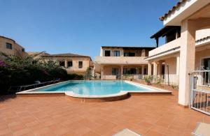 a swimming pool in front of a house at Two Bedroom With Pool Taty Apartment in Porto Cervo