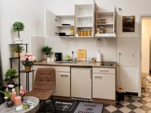 a kitchen with white cabinets and a sink and a table at Peaceful & Cozy Apartment in Dresden