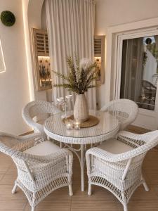 a white table with chairs and a vase with a plant at Apartment Natasa in Rab