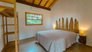 a bedroom with a bed in a room with a window at Reserva Cambucá - Afeto, Pessoas e Sabores in Itirapina
