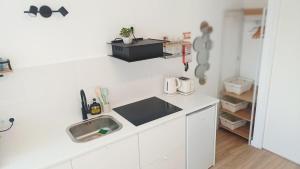 a white kitchen with a sink and a counter at Seabird Lisbon Studio in Charneca