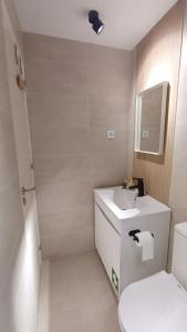 a bathroom with a sink and a toilet and a mirror at Seabird Lisbon Studio in Charneca +40 photos