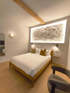 a bedroom with a bed with a window and a chair at Insula Domo in Nuoro +5 photos