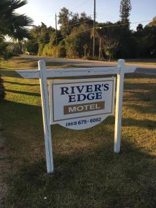 a sign for a rivers edge motel on the side of a road at The Rivers Edge Motel in La Belle