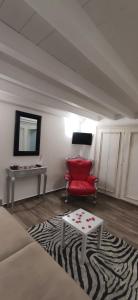 a living room with a red chair and a table at Mariposa in Capodimonte
