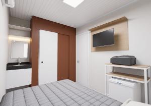 a bedroom with a bed and a flat screen tv at Hotel JB in Juazeiro do Norte