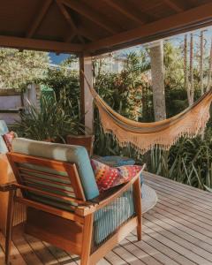 a porch with a hammock on a deck at Villa Gardena Suites in Praia do Rosa