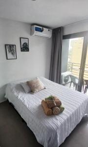 a bedroom with a white bed with towels on it at Centro suite II in Santiago del Estero