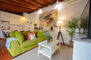 a living room with a green couch and a table at El Rincón Del Huroncillo in Tejina