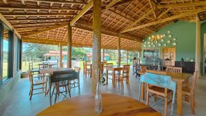 a dining room with wooden tables and chairs at Reserva Cambucá - Afeto, Pessoas e Sabores in Itirapina