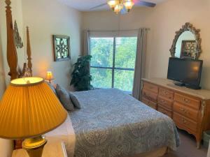 a bedroom with a bed and a television and a dresser at IC 216 Inverness Condos Comal River in New Braunfels