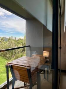 a balcony with a wooden table and a window at Rioverde Living suites- Apartahotel in Rionegro