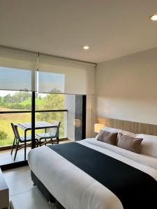 a bedroom with a large bed and a table at Rioverde Living suites- Apartahotel in Rionegro