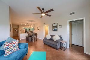 a living room with a blue couch and a ceiling fan at IC 302 Ripley River Haus in New Braunfels +22 photos
