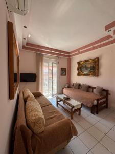 a living room with a couch and a bed at Pieria Paralia Apartment in Paralia Katerinis