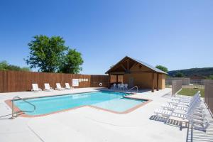 a swimming pool with chairs and a building at RG 105 Rio Refuge in Canyon Lake +18 photos