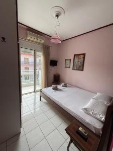 a bedroom with a bed and a large window at Pieria Paralia Apartment in Paralia Katerinis