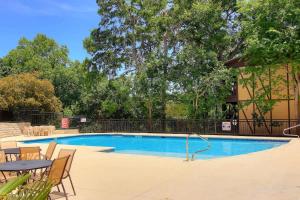 a swimming pool with chairs and a table next to a building at CW C207 River Zen in New Braunfels