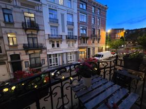 a balcony with a wooden bench and a building at Peaceful Pad in Brussels