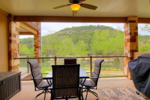 a screened in porch with a table and chairs at RG 208 Rivendell On The Guadalupe in Canyon Lake