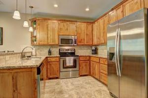 a kitchen with wooden cabinets and a stainless steel refrigerator at RG 208 Rivendell On The Guadalupe in Canyon Lake