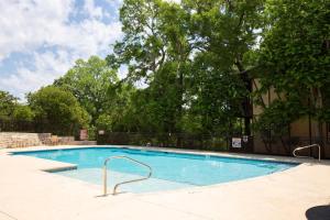 a large swimming pool in a yard with trees at CW C101 Condo de Comal in New Braunfels