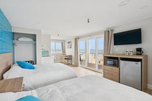 a hotel room with two beds and a flat screen tv at The Voyager in Old Orchard Beach