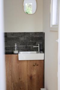 a bathroom with a white sink and a mirror at Knus Relaxchalet met Privé Hottub in Voorthuizen +21 photos