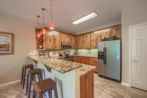 a kitchen with wooden cabinets and a refrigerator at RG 203 Riverview Terrace in Canyon Lake