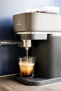 a coffee maker is making a cup of coffee at Knus Relaxchalet met Privé Hottub in Voorthuizen