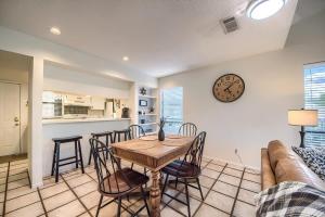 a living room with a table and chairs and a clock at TBM 112 Among The Oaks in New Braunfels