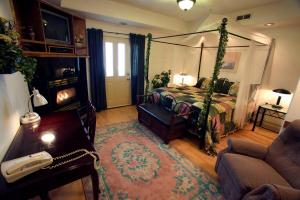 1 dormitorio con cama con dosel y sofá en Abbey Archway Inn en Fairbanks