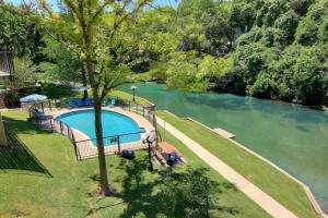 an overhead view of a swimming pool next to a river at IC 110 Comal Corral in New Braunfels +19 photos