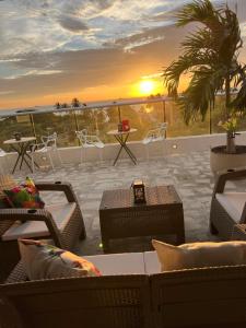 a patio with tables and chairs and a sunset at Ritacuba House Boutique in Santa Marta