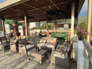 an outdoor patio with chairs and tables and a bar at Ritacuba House Boutique in Santa Marta