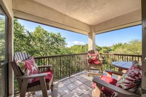 a porch with two chairs and a table on a balcony at IC 316 Riverfront Bliss in New Braunfels