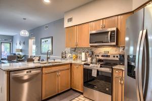 a kitchen with stainless steel appliances and wooden cabinets at IC 316 Riverfront Bliss in New Braunfels