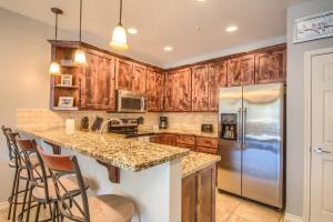 a kitchen with wooden cabinets and a island with bar stools at RG 306 Hillside River Retreat in Canyon Lake