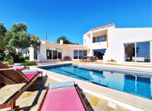 a villa with a swimming pool and a house at Casa da Madrugada in Salema