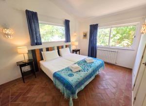 a bedroom with a large bed and two windows at Casa da Madrugada in Salema