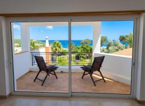 two chairs on a balcony with a view of the ocean at Casa da Madrugada in Salema