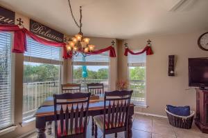 a dining room with a table and chairs and windows at WW D302 Chateau Relaxeau in New Braunfels